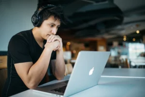 Person sitting in front of a computer with headphones